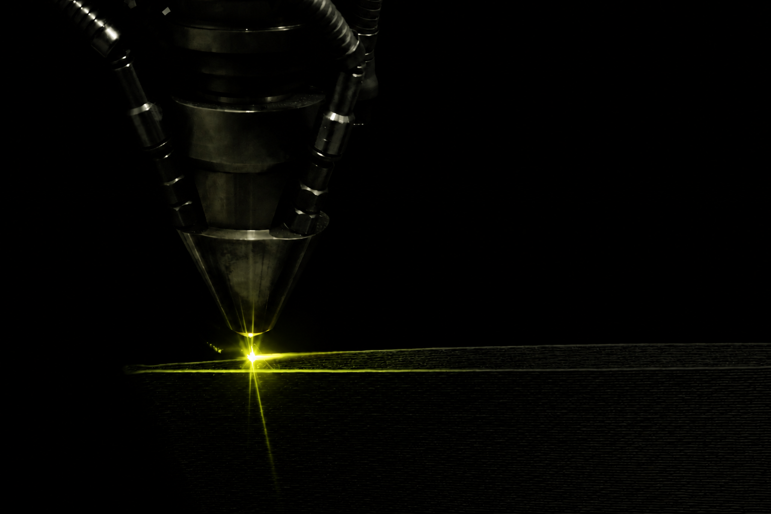 Directed-energy deposition nozzle fusing metal layers onto an additive manufacturing build